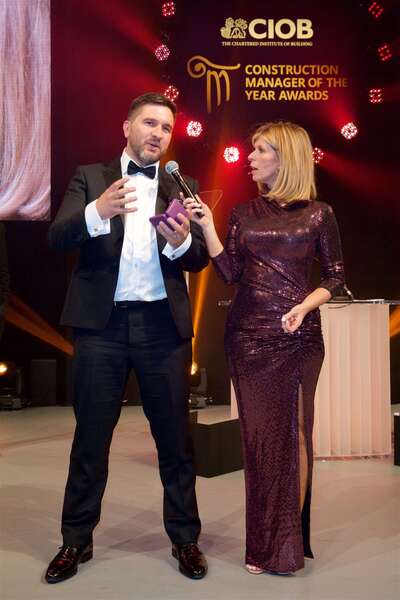 Award ceremony with host interviewing a winner.