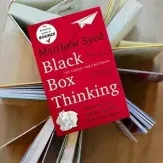 Red "Black Box Thinking" book on open pages